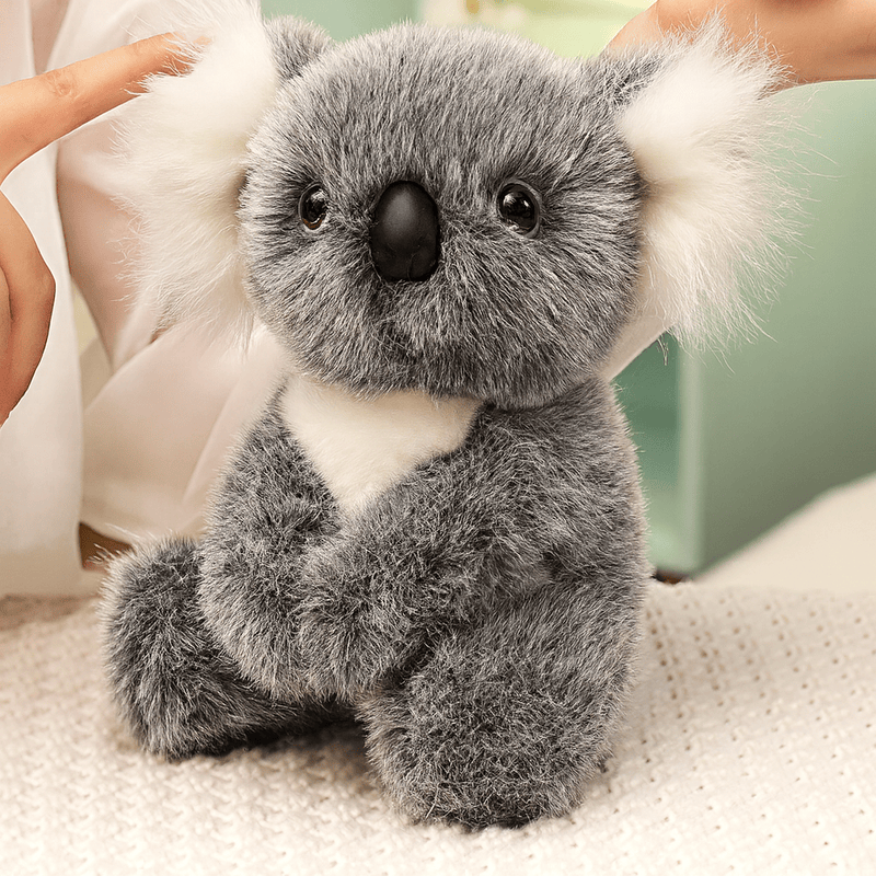 Peluche koala gris grande famille sur une nappe sur une table