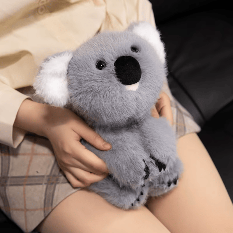 Peluche koala kawaii assis sur les genoux d'une fille