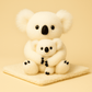 Peluche koala blanc mère et fils sur couverture