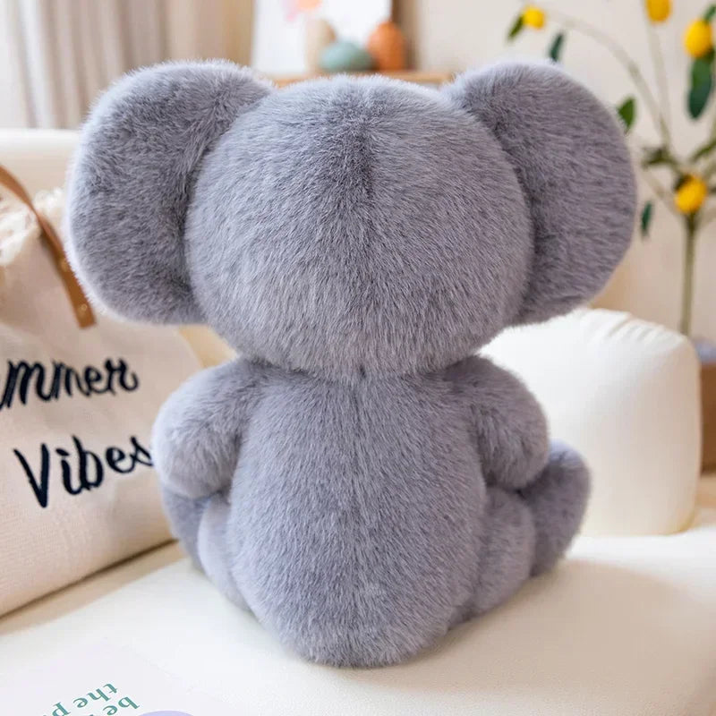 Peluche koala mignonne de dos assise sur un canapé