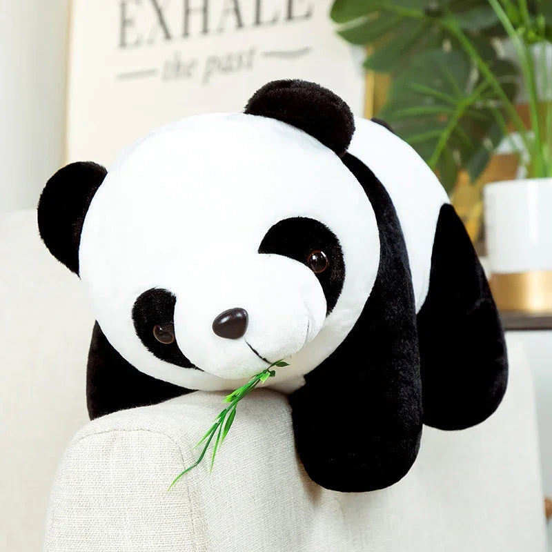 Peluche panda avec ses feuilles de bambou sur canape
