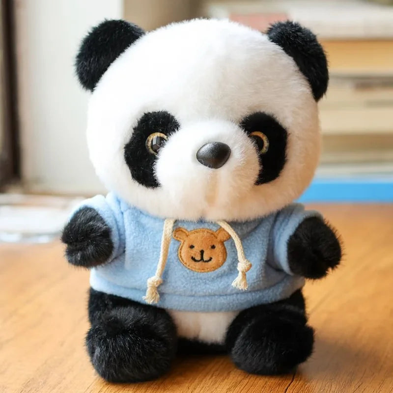 Peluche panda avec son pull bleu sur un bureau