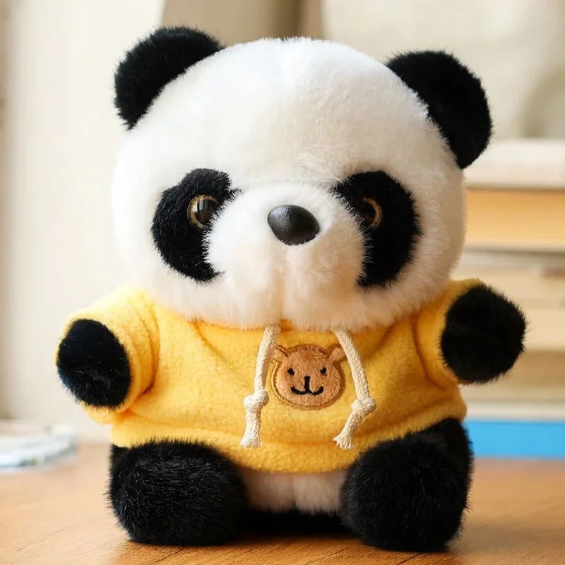 Peluche panda avec son pull jaune sur un bureau
