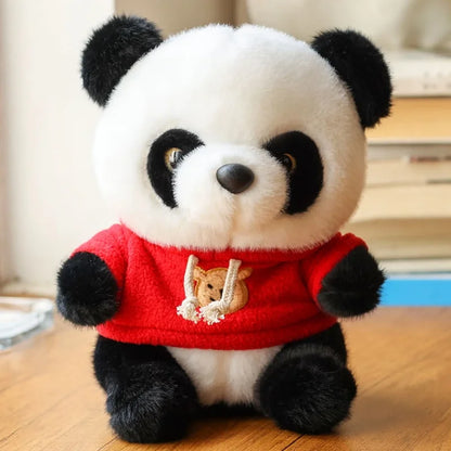 Peluche panda avec son pull rouge sur un bureau