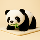 Peluche panda sur couverture avec ses feuilles de bambou