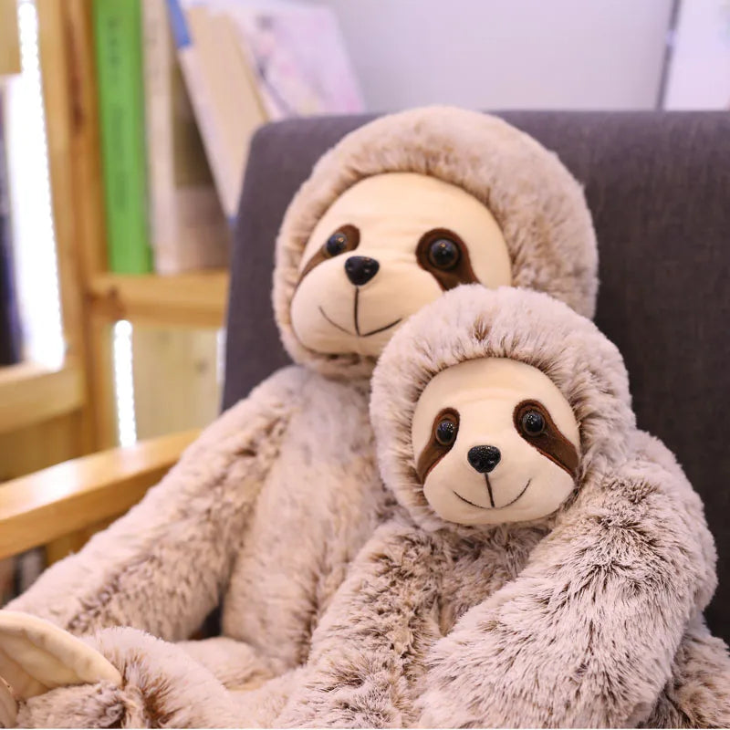 Deux peluches paresseux assis sur un fauteuil 