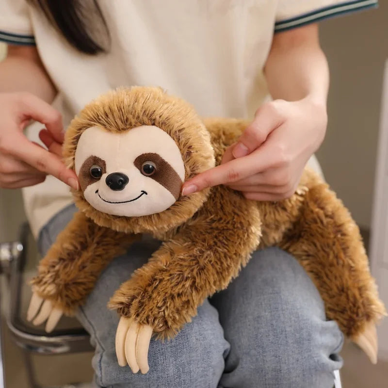 Peluche paresseux brun heureux sur les genoux d'une fille