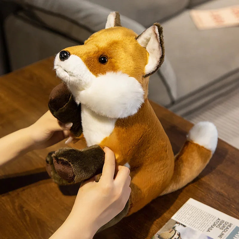 Peluche renard domestique tenu par une fille par les pattes 