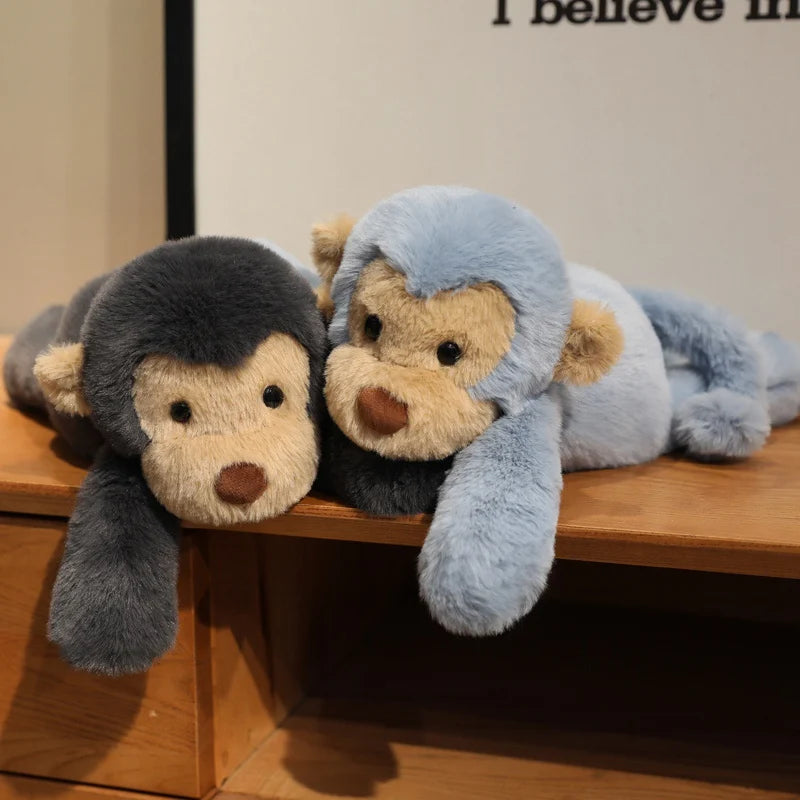 Deux peluches singes douces couché sur un meuble