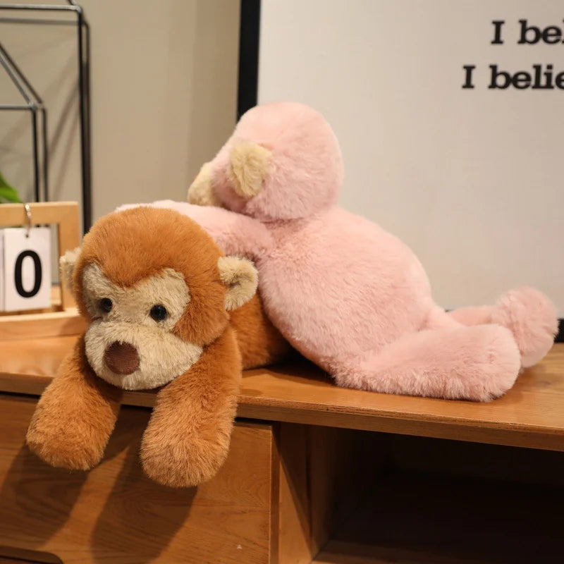 Deux peluches singes douces couchées l'une sur l'autre sur un meuble