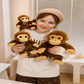 Trois peluches singes mignonnes dans les bras d'une fille