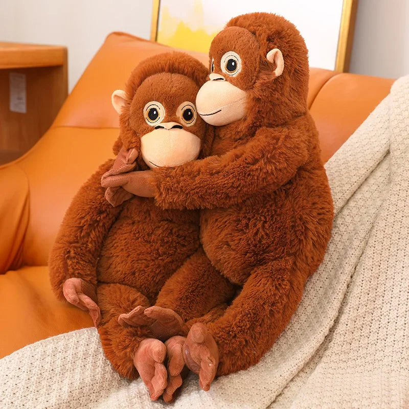 Deux peluches singes orang-outan entrelacés sur un fauteuil