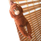 Peluche singe orang-outan accroché sur un store en bois