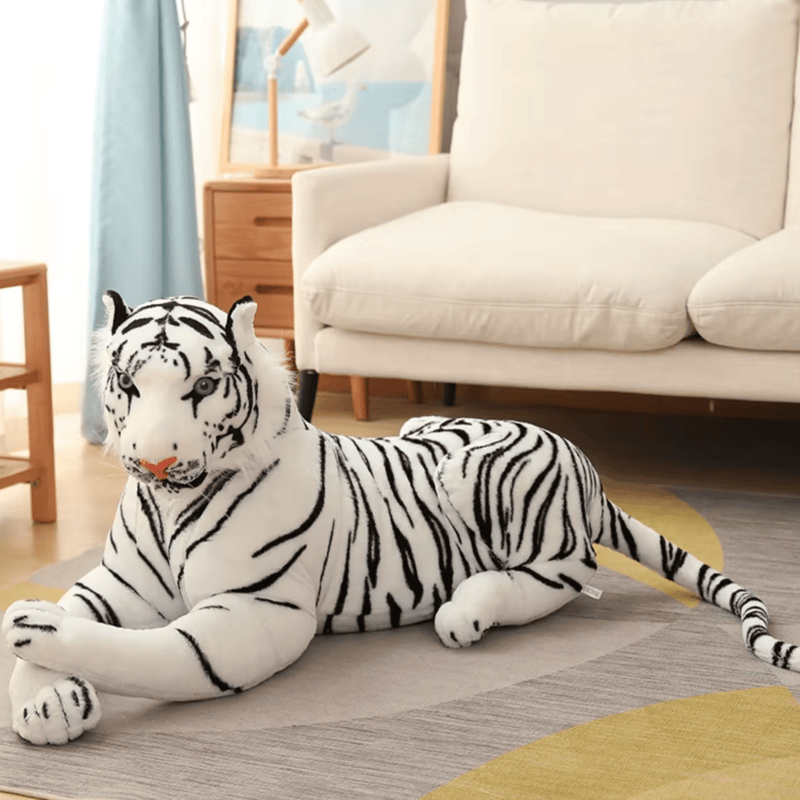 Peluche tigre blanc allongé sur un tapis