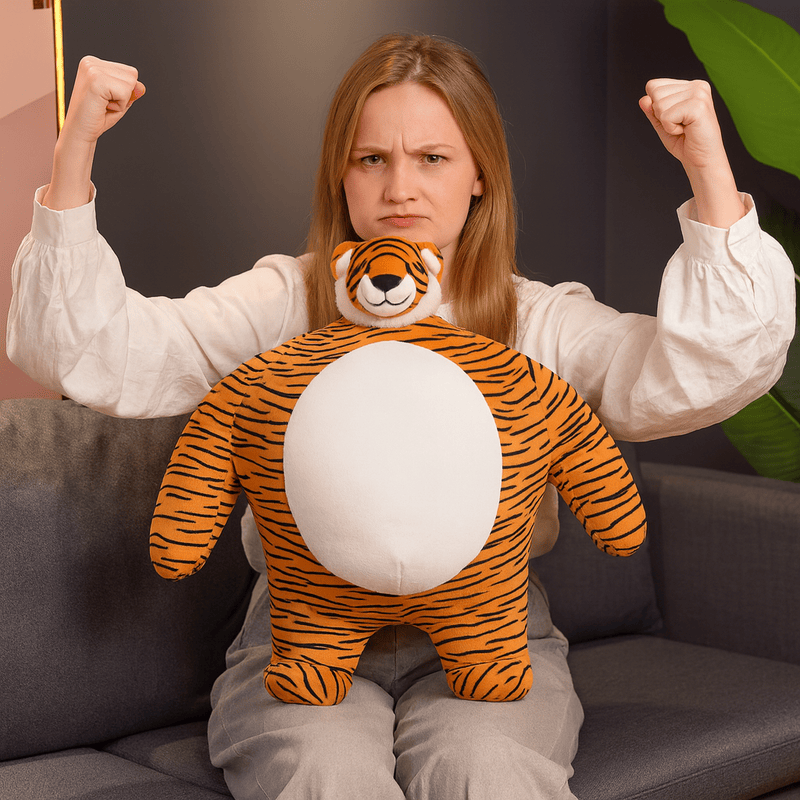 Peluche tigre super-héros sur une les genoux d'une fille assise sur un canapé