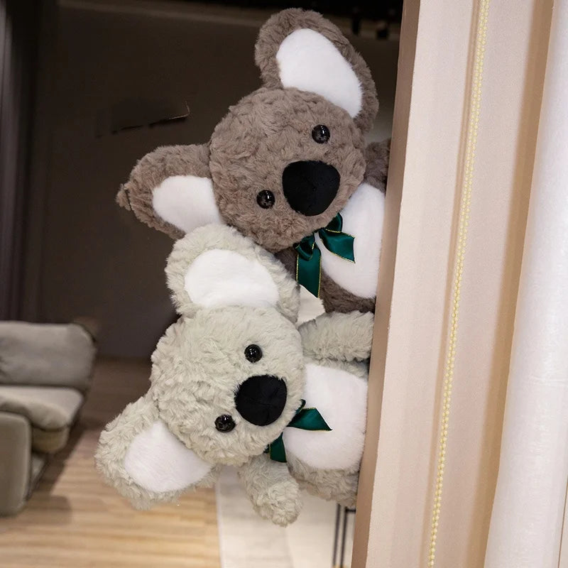 Deux peluches koalas derrière une porte